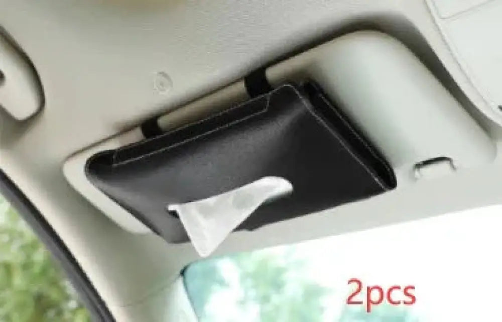 Premium leather car sun visor tissue box holder in black with a sleek rectangular design and white tissue partially pulled out