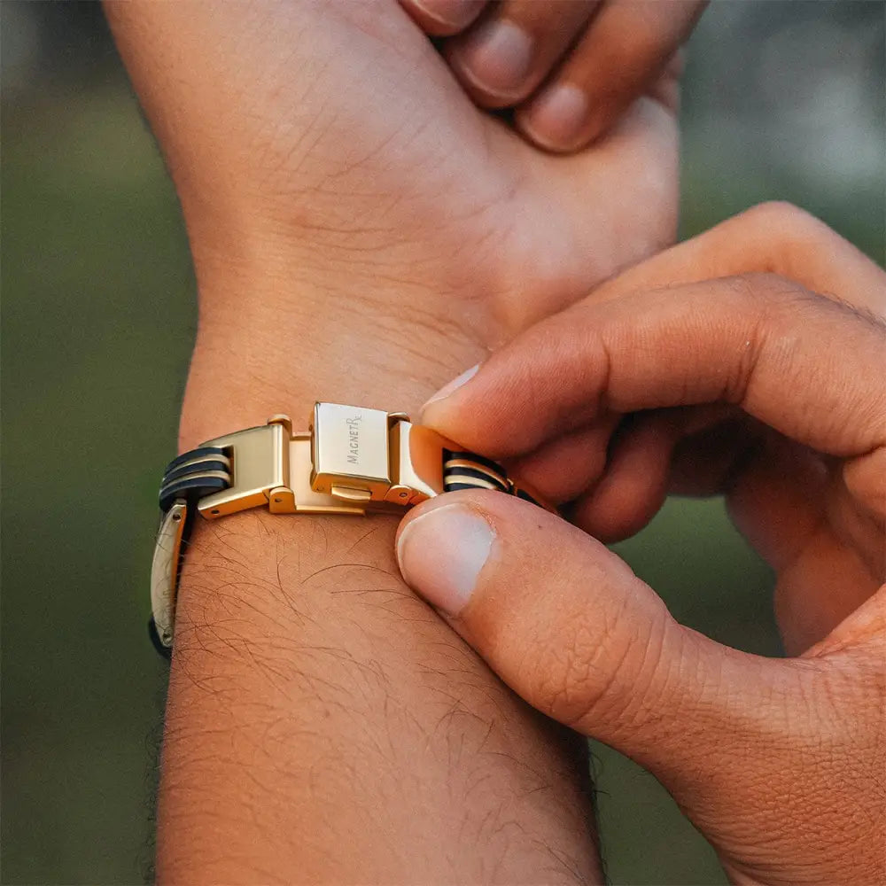 Men’s gold titanium magnetic bracelet with gold-tone clasp and black and white striped leather straps with carbon fiber inlays