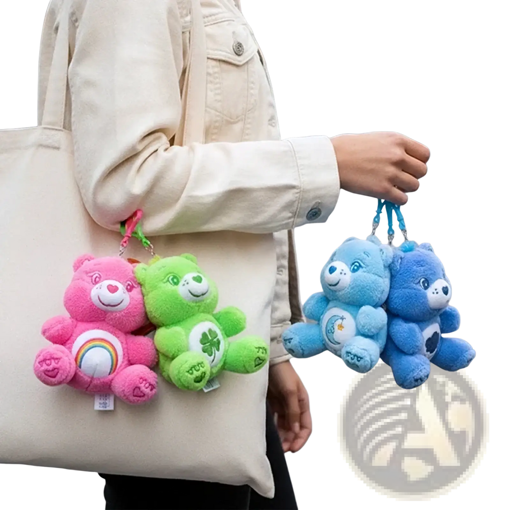 A set of four plush care bears keychains featuring pink, green, and blue bears with distinctive patch designs