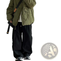 Olive green corduroy puffer jacket with black shoulder strap and tan leather accent paired with loose fit olive green twill cargo pants