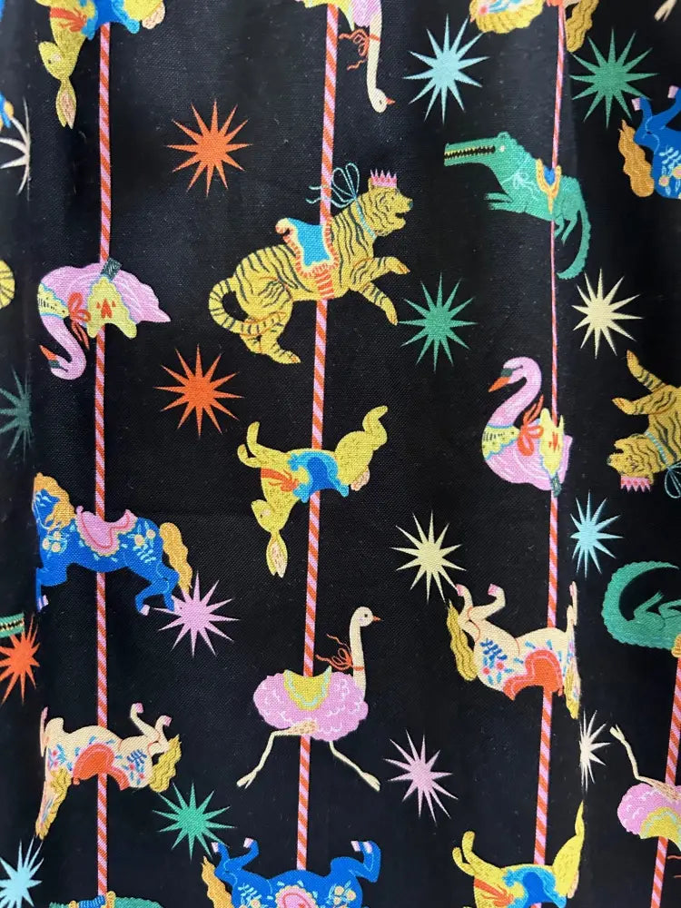 Black cotton fit and flare mini dress with vibrant retro carousel print featuring colorful tigers and swans