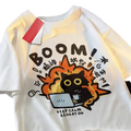 White cotton oversized t-shirt featuring a cartoon black cat with orange flames and bold brown text boom keep calm carry on