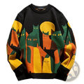 Black knit oversized sweater featuring vibrant orange and green cartoon cat silhouettes against a yellow sun
