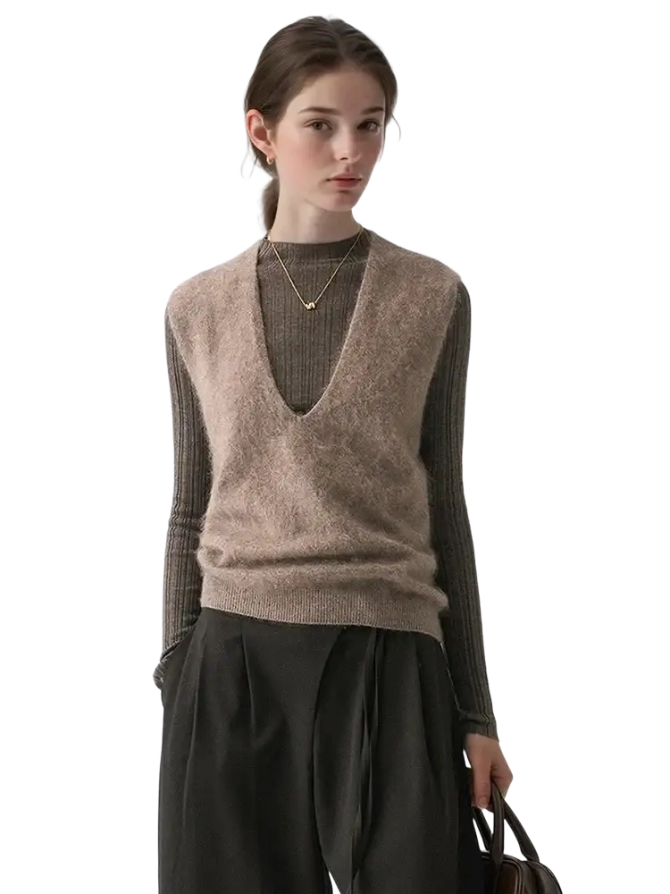A soft beige cashmere wool v-neck sweater vest with a fuzzy knit texture worn over a ribbed long-sleeve top