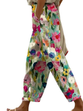 Casual floral print wide leg pants featuring vibrant pink blue yellow and green blossoms on light cream fabric