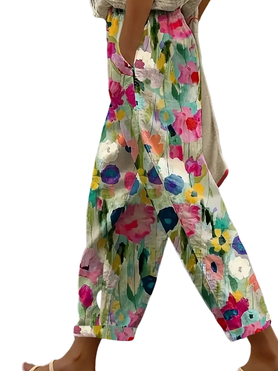 Casual floral print wide leg pants featuring vibrant pink blue yellow and green blossoms on light cream fabric