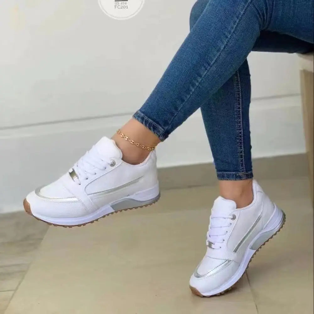 White women’s casual walking sneakers with metallic silver accents and chunky sole for comfortable wear