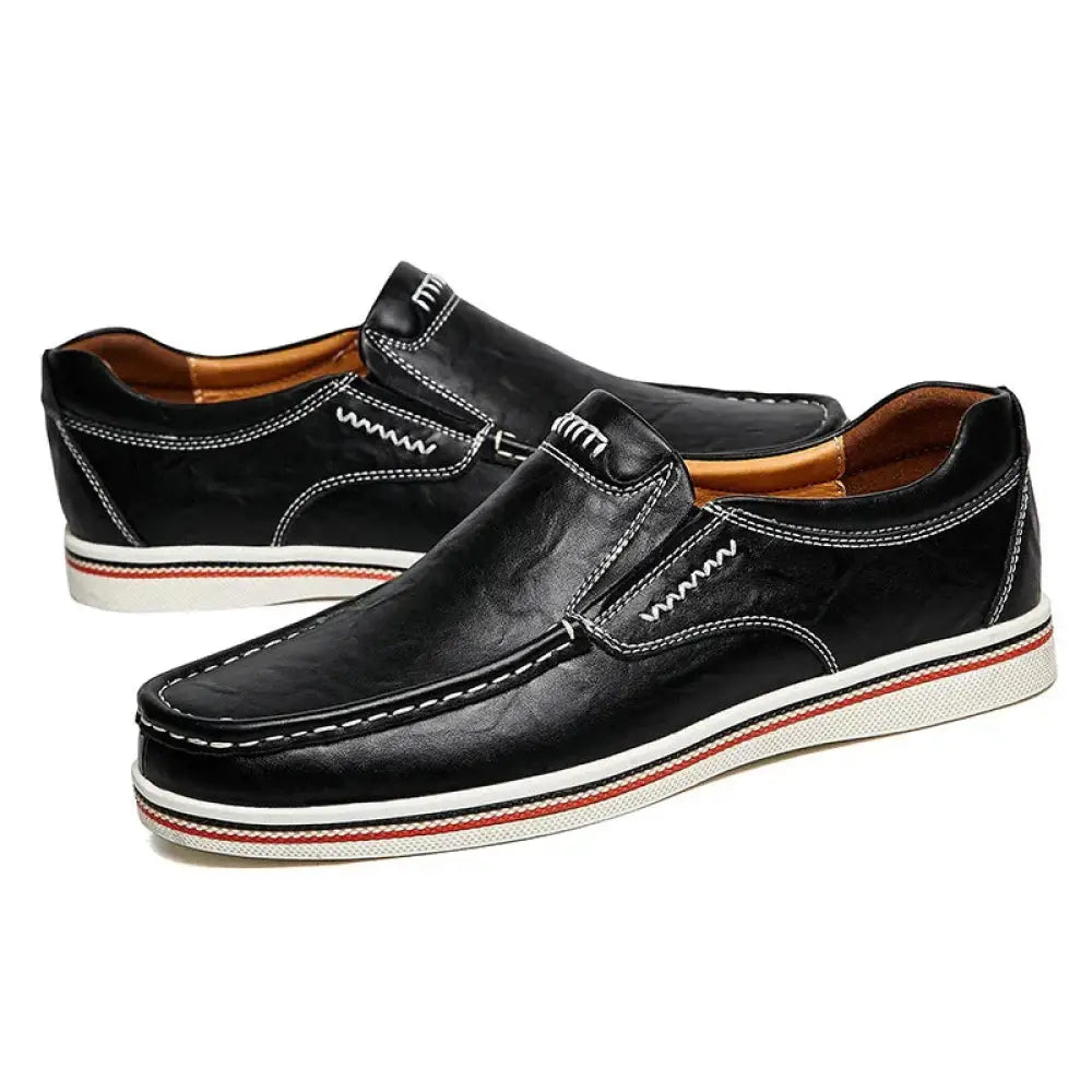 Black leather men’s British slip-on shoes with white stitching and a red striped sole for stylish comfort