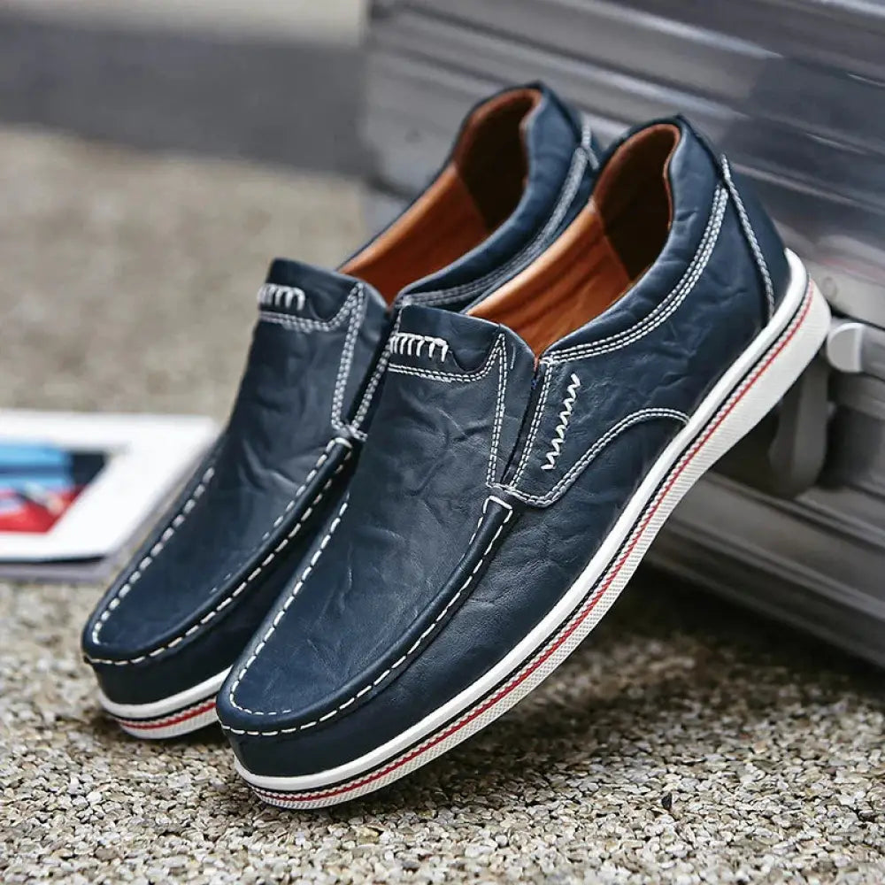 Men’s British leather slip-on shoes in navy blue with white stitching and red and white striped rubber sole