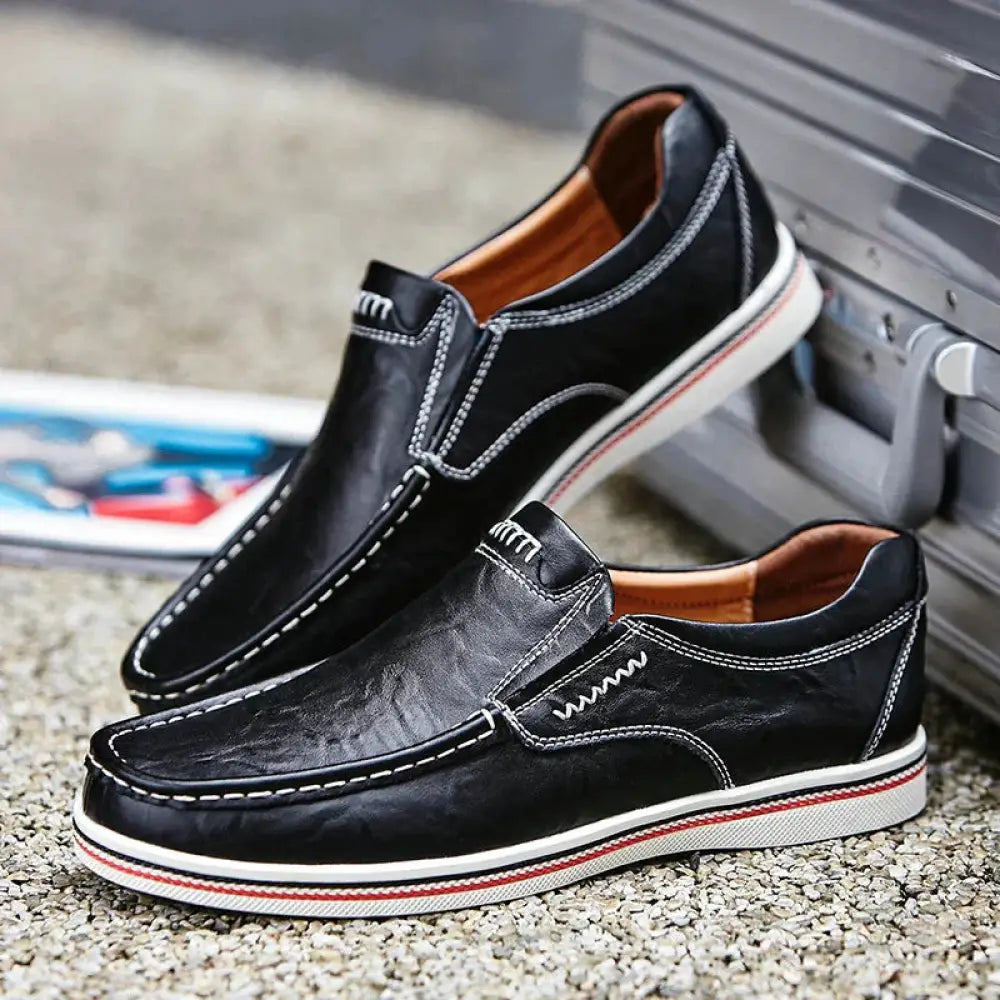 Men’s British leather slip-on shoes in black with white stitching and red and white striped sole