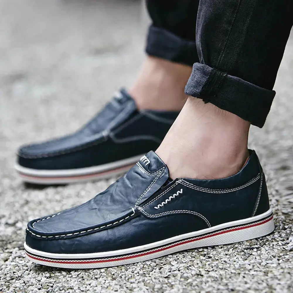 Men’s British leather slip on shoes in dark blue with white stitching and red and white striped rubber sole