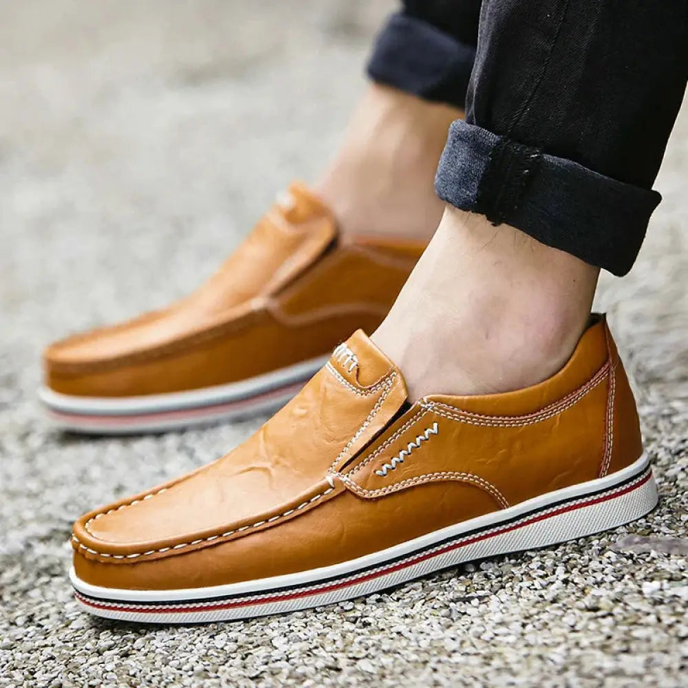 Men’s British leather slip-on loafers in tan with white stitching and a striped rubber sole