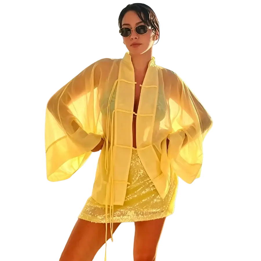 A casual shirt sheer yellow long sleeve blouse with a flowing translucent fabric wide sleeves and vertical tie closure