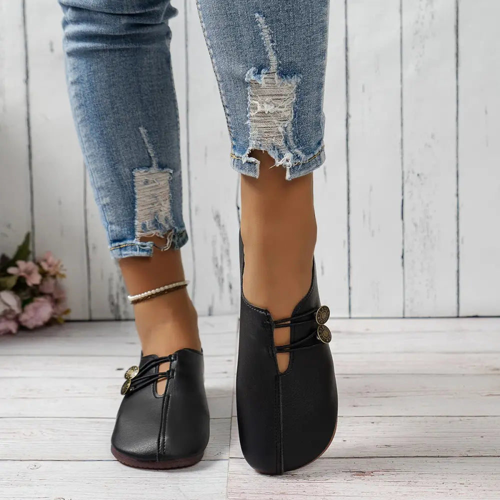 Black leather women’s square toe slip-on loafers with decorative gold-toned button details