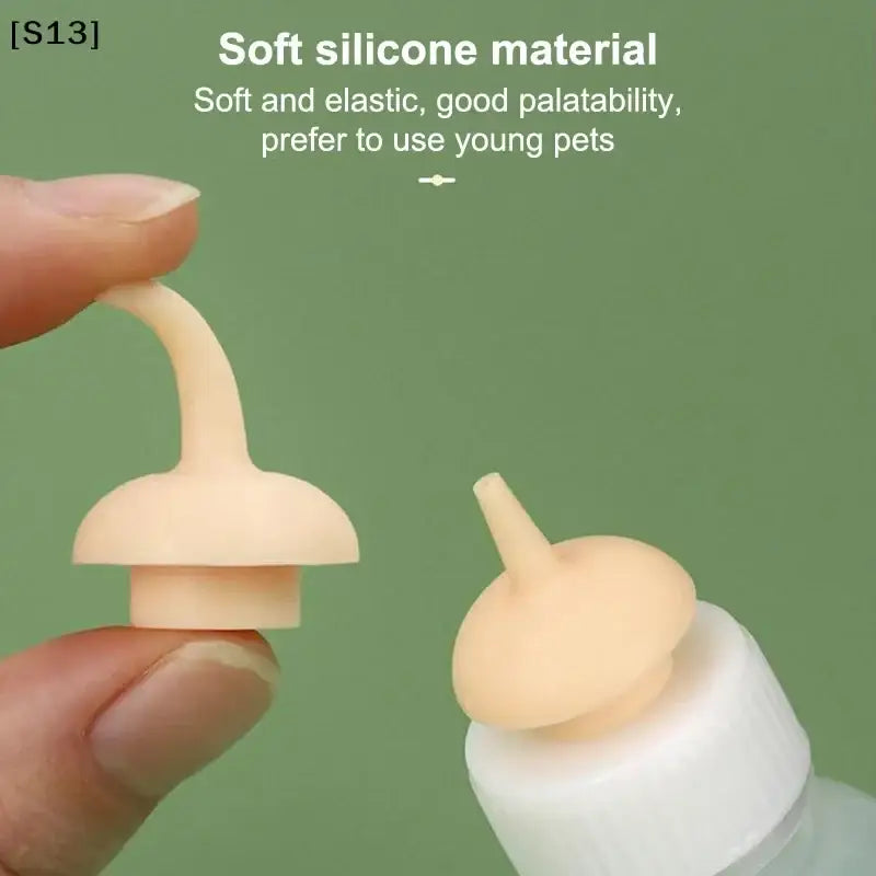 Beige soft silicone cat bottle feeder with unique curved spout and rounded base for newborn pets with measuring scale