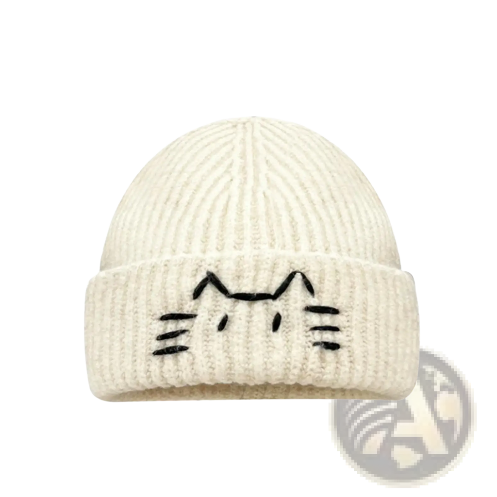 Cream-colored ribbed knit beanie hat with a black embroidered cat face on the folded brim