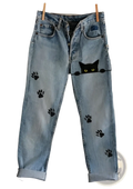 Light-wash faux denim flared trousers with black cat paw prints and a peeking black cat face design