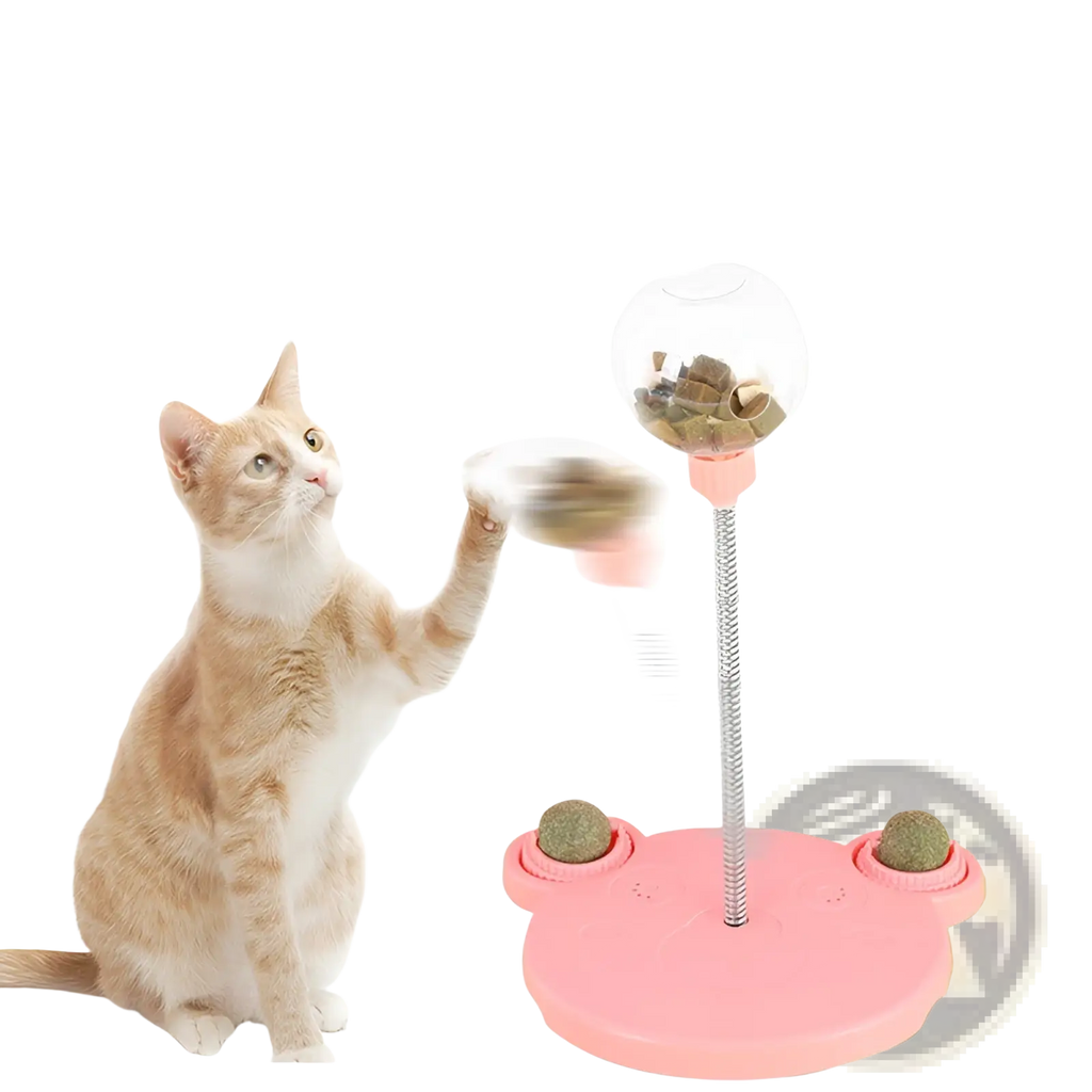 Cat puzzle toy tumbler food dispenser in pink shaped like a frog with three treat-filled rotating clear spheres and a silver pole