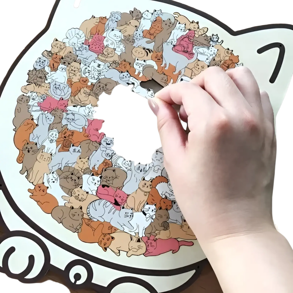 A hand places a cat-shaped wooden piece onto a circular colorful cat-themed morandi jigsaw puzzle with 135 pieces