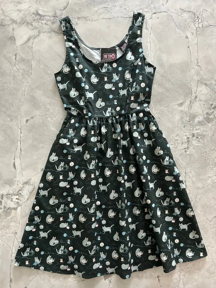 A dark green cotton cats and yarn vintage fit and flare midi dress with a playful white and gray cat pattern