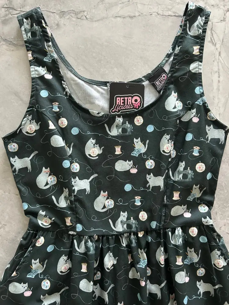 Black sleeveless cotton midi dress with white cat sewing pattern and blue pink yarn balls vintage fit and flare style