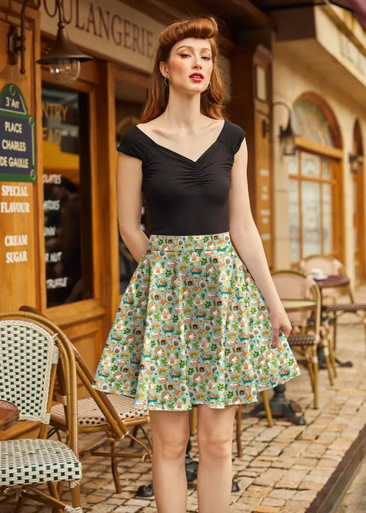 A vintage-inspired light green a-line skirt featuring playful cartoonish characters and shamrock patterns