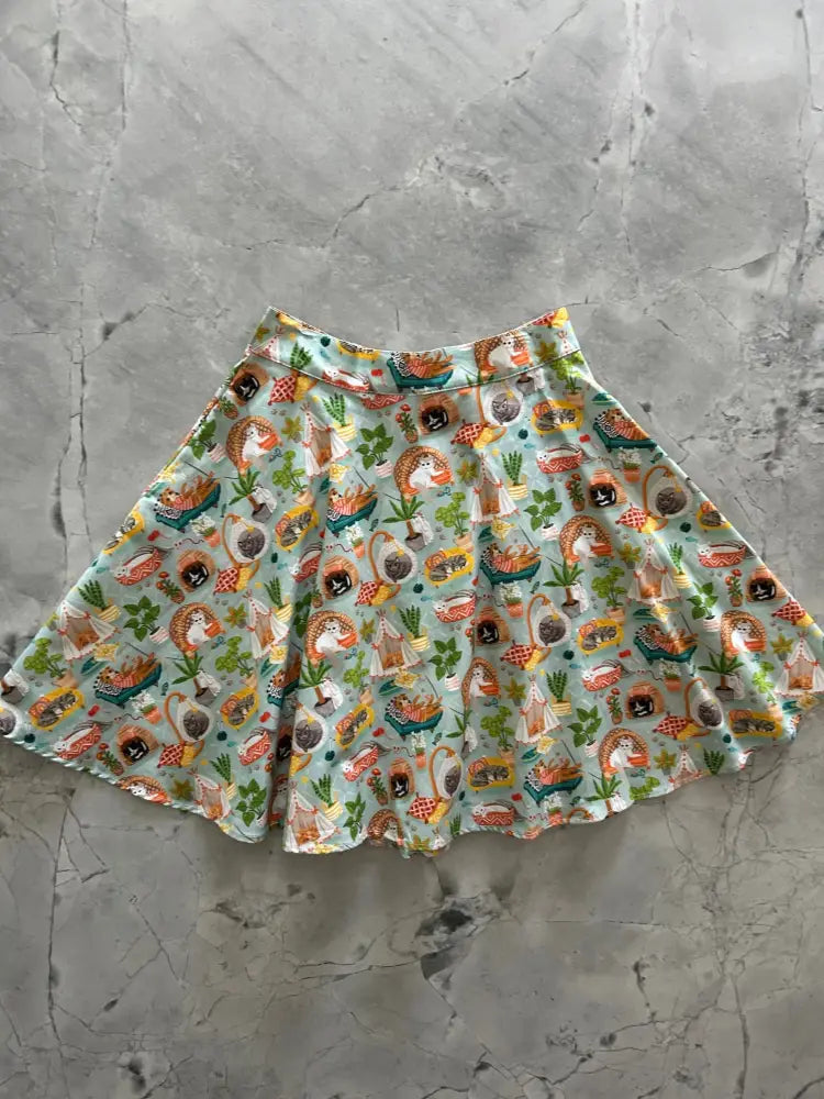 A flared cats and plants vintage a-line skater skirt with a playful hedgehog and kitchen item pattern on light mint green