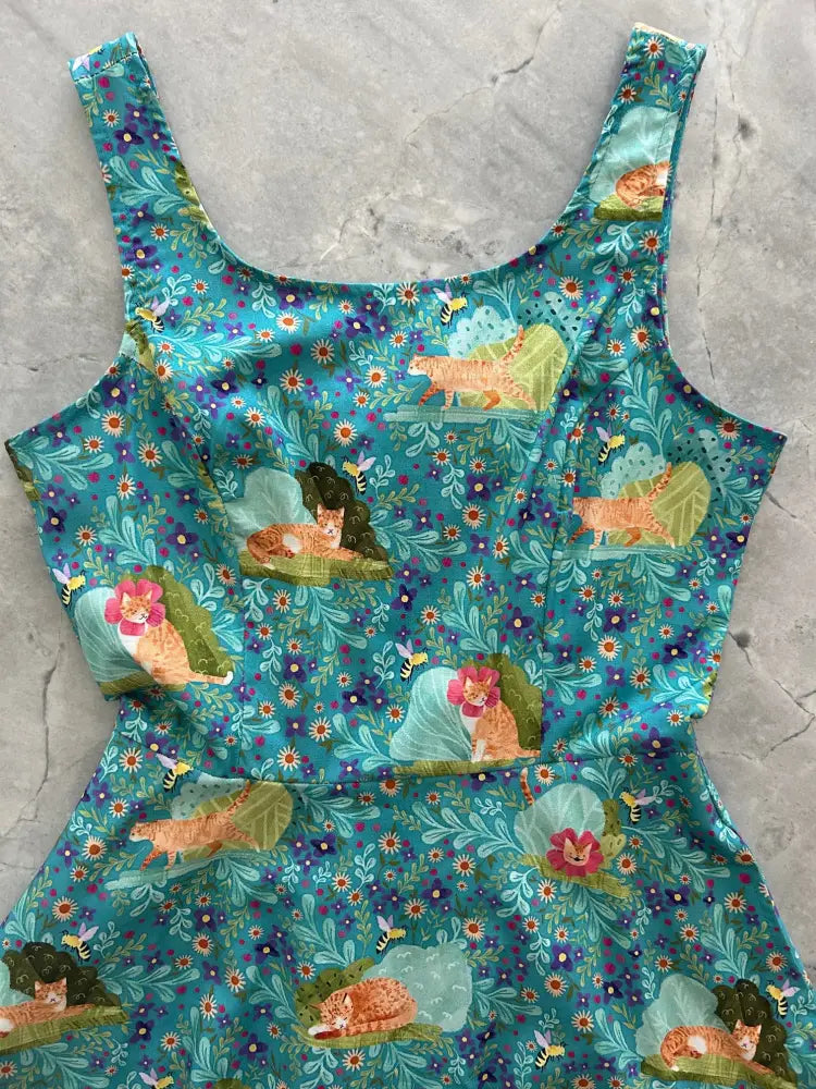 Teal floral cat print sleeveless skater dress with pockets featuring sleeping orange tabby cats and colorful flowers