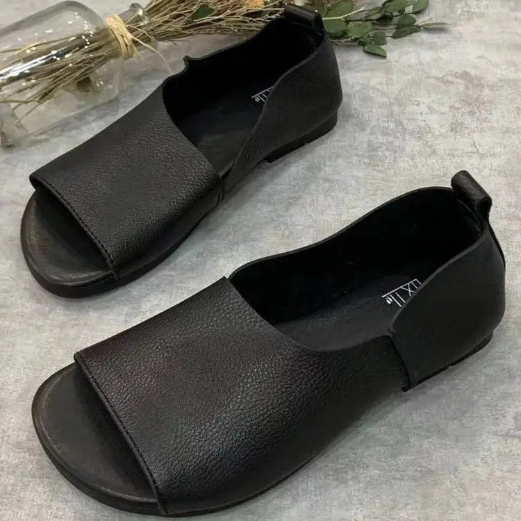 Sandalias de cuero color negro tipo mocasín con diseño minimalista y suela blanda, con estilo retro de punta descubierta.