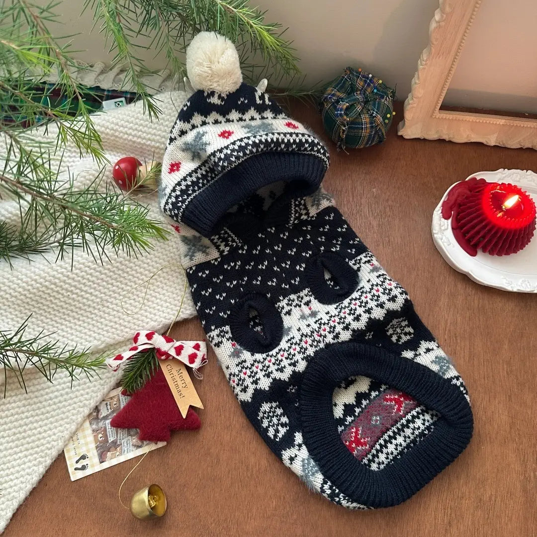Pull en tricot pour chien nordique noir, blanc et gris, avec un motif festif et un pompon duveteux sur le dessus, conçu comme vêtement d’hiver chaud pour animaux de compagnie.