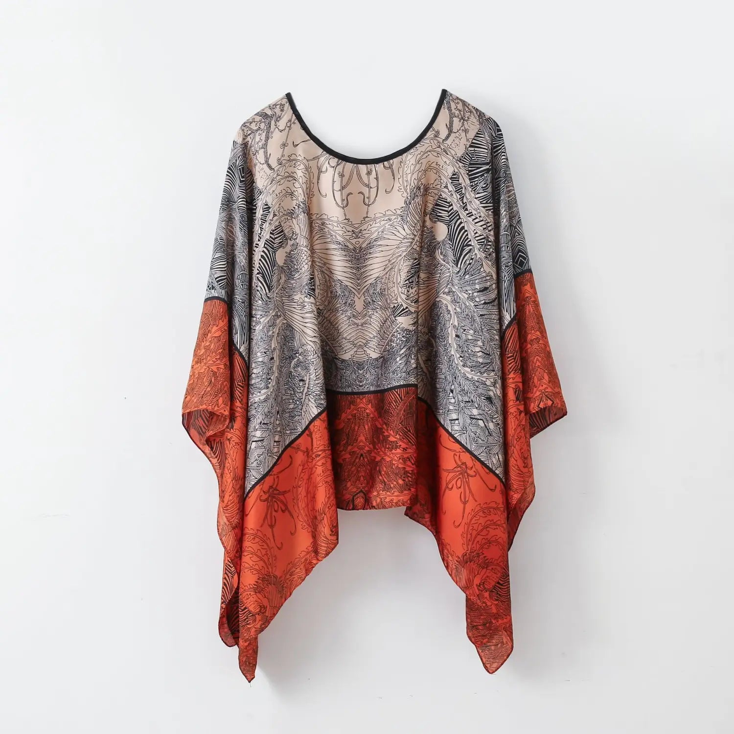 A flowing asymmetrical printed silk patterned pullover shawl cape outerwear in black gray and vibrant orange with intricate line art patterns.