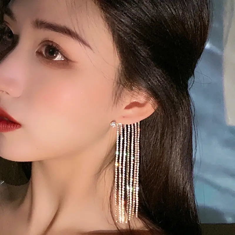 Crystal tassel 14k gold plated long drop earrings featuring multiple strands of sparkling rhinestones in a gold-tone metal finish.