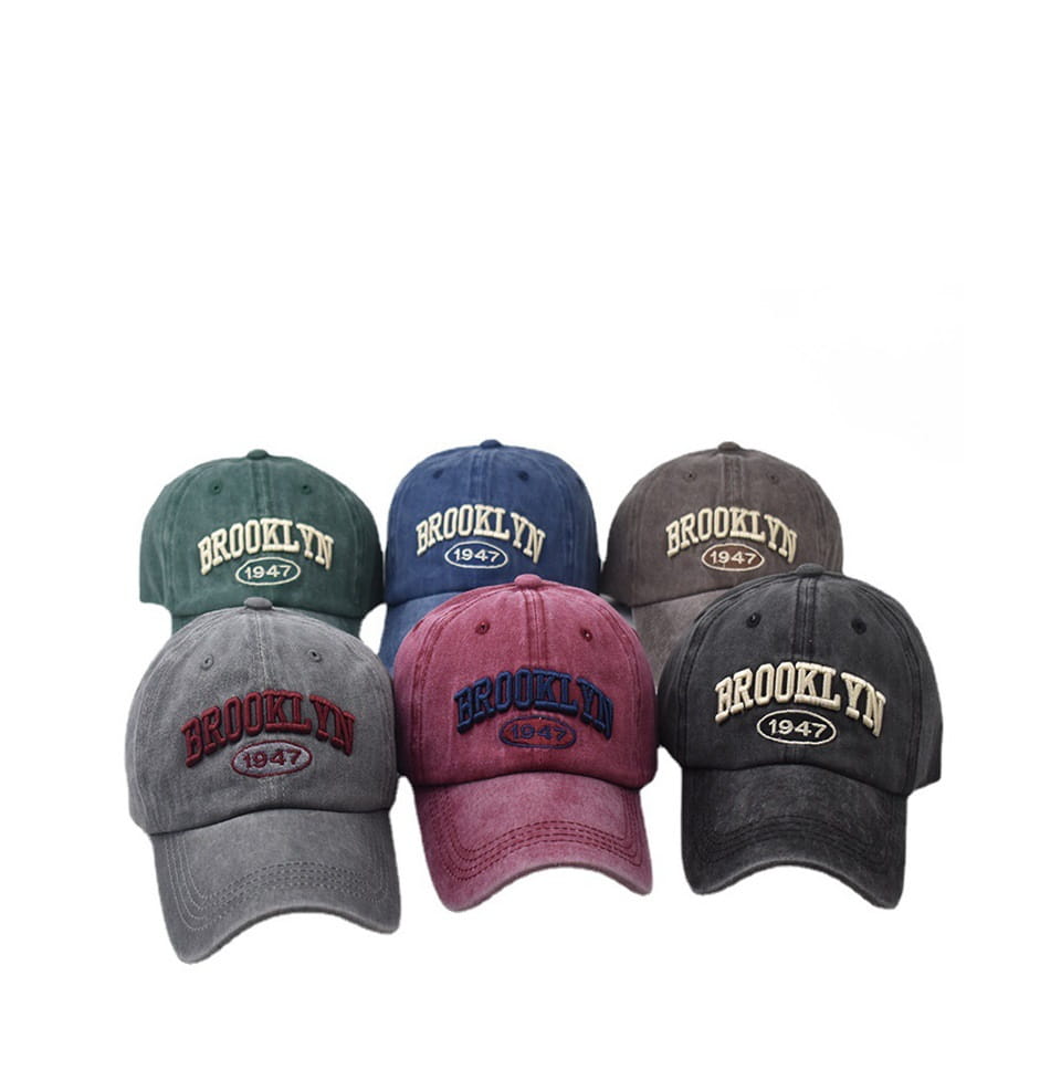 A collection of six vintage-style cotton baseball hats in muted colors featuring embroidered brooklyn 1947 lettering and a circular emblem.