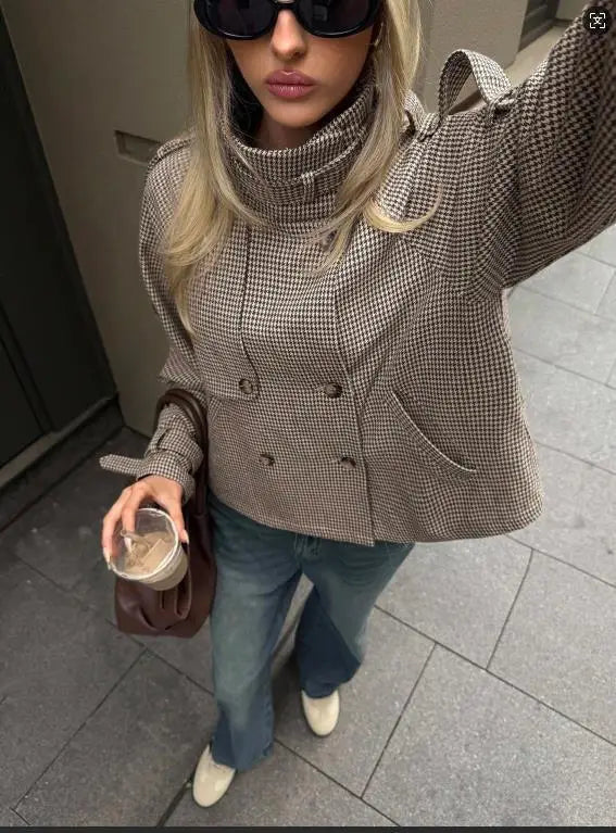 Brown houndstooth double-breasted coat with toggle closures and shoulder straps in a relaxed fit design.
