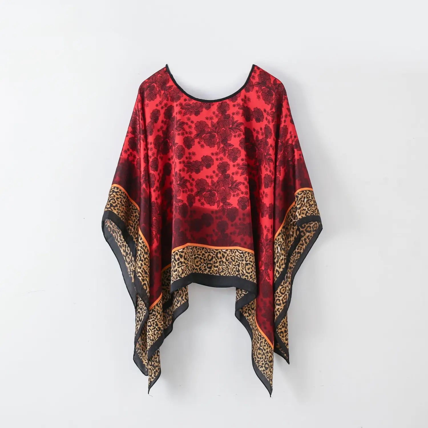 A vibrant red satin printed silk patterned pullover shawl cape outerwear with a black floral pattern and leopard print trim.