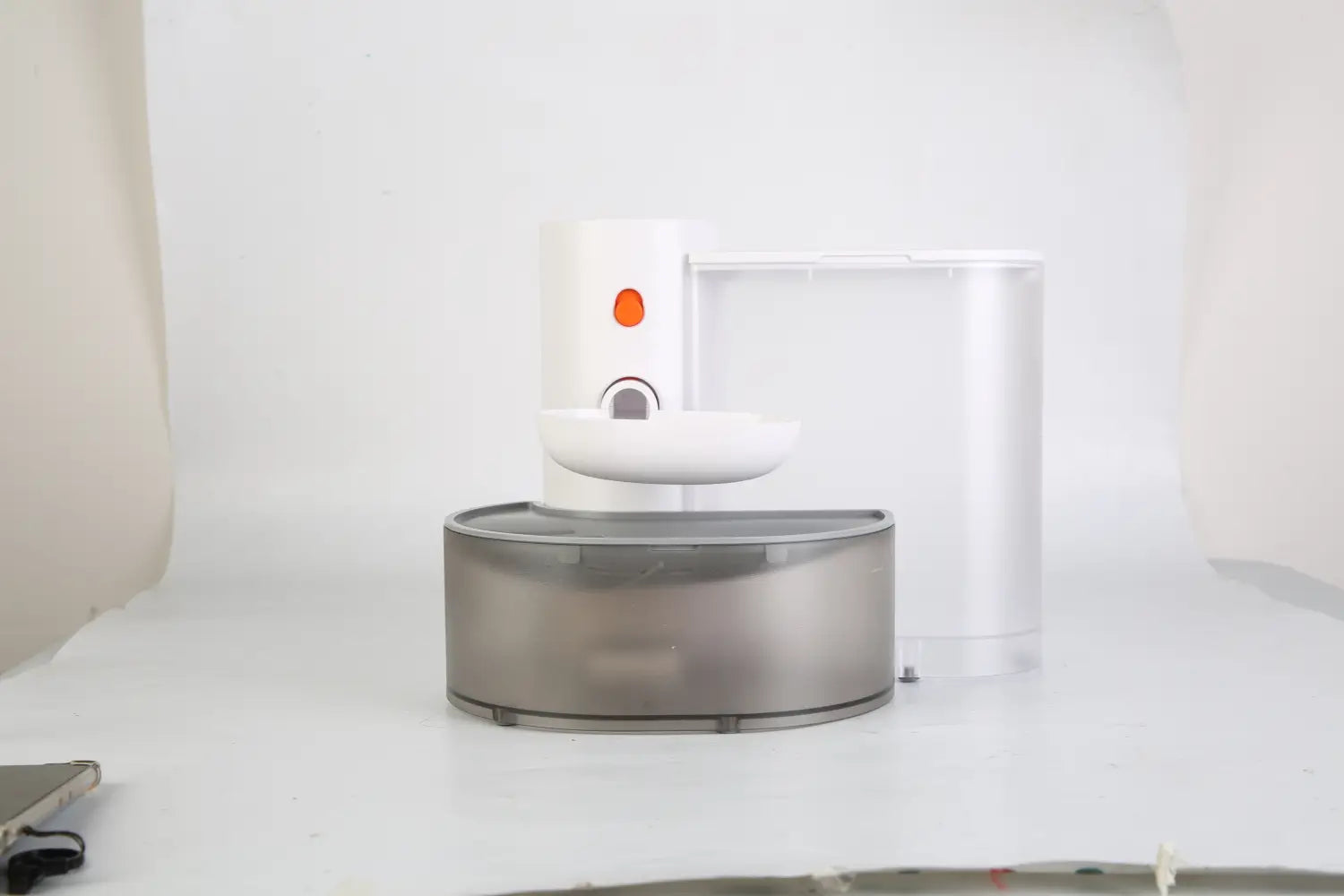 Fontaine à eau intelligente pour animal de compagnie 3 L sans fil rechargeable blanche et argentée, avec une cuvette, au design moderne et élégant, dotée d’un bouton orange sur le dessus.