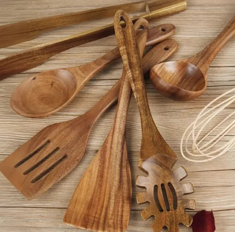 Set of seven wooden cooking utensils with natural wood grain and smooth rounded edges designed for non stick kitchen use.