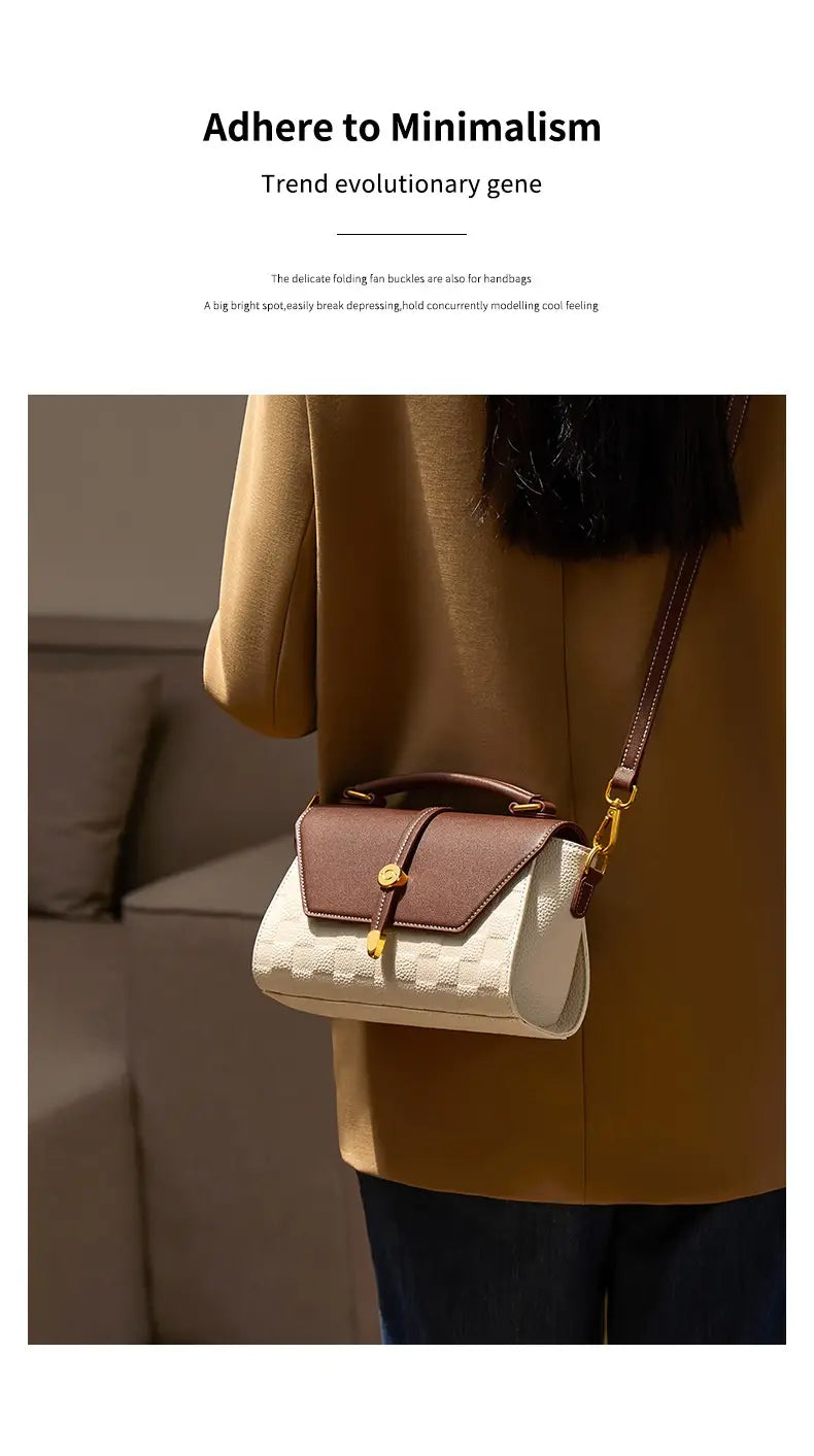 Eine minimalistische zweifarbige Webleder-Crossbody-Handtasche mit weißem, strukturiertem Körper, braunem Leder-Flip und Griff, akzentuiert durch goldfarbene Beschläge.