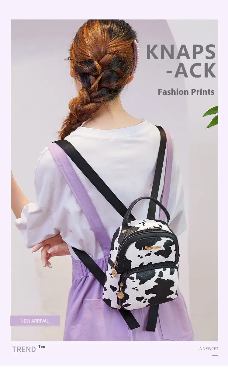 Mini backpack featuring black and white cow print with gold tone hardware in Korean style design.