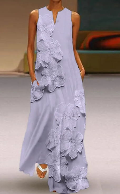 Une robe longue sans manches mauve déployant une dentelle florale appliquée élégante avec des détails floraux blancs superposés et délicats le long du côté.