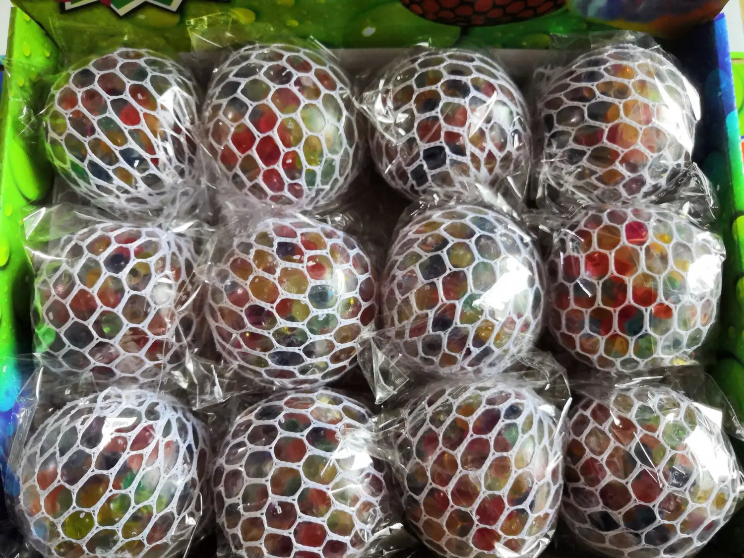 led mesh stress ball glowing grape squeeze toy featuring colorful translucent gel-filled balls encased in white mesh netting for stress relief.