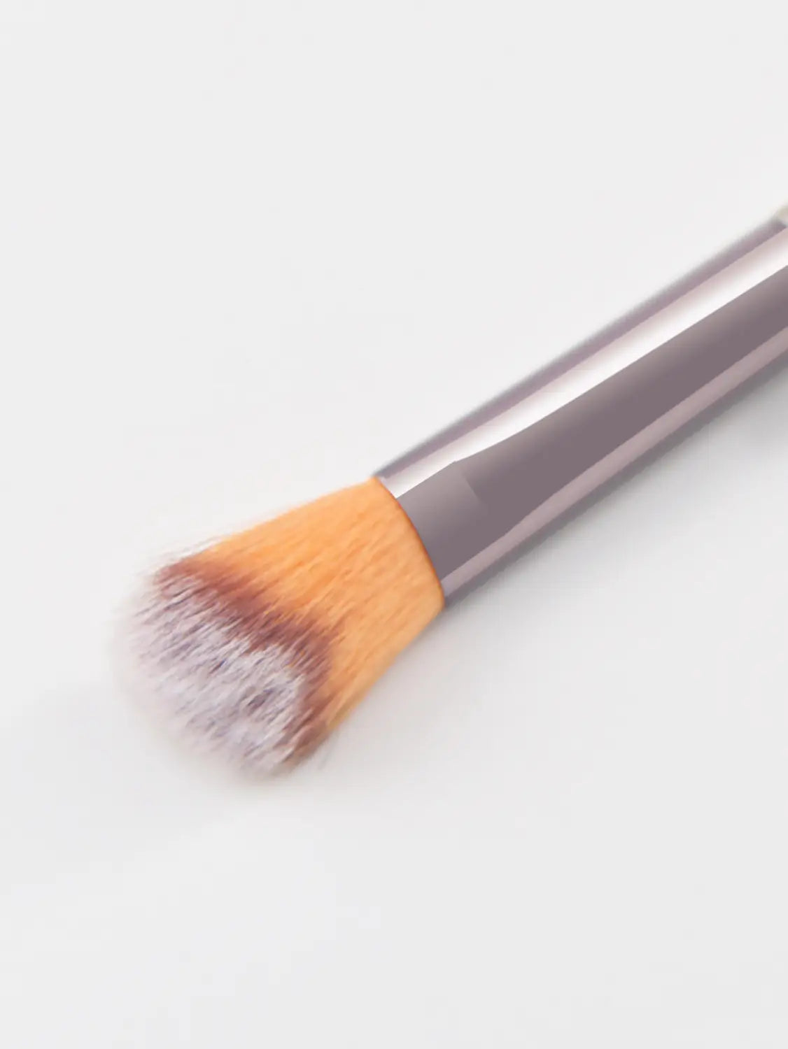 A sleek metallic gray finger belly makeup brush with a dense tapered head of soft orange and white bristles designed as a professional contour tool.