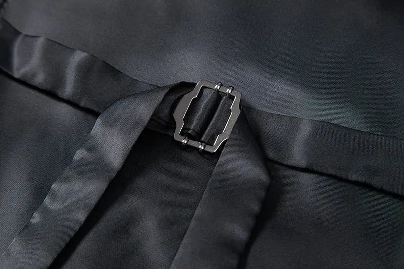 Correa de satén negro con hebilla metálica plateada en la parte posterior de un chaleco de traje tipo sastre doble abotonado de espiga para hombre.
