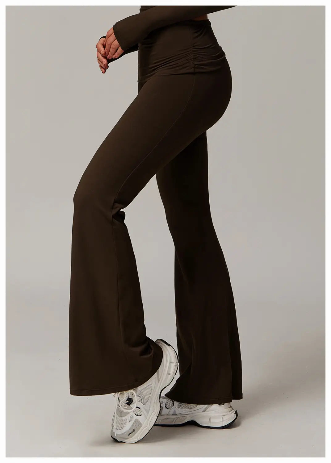pantalones de yoga acampanados de cintura alta en marrón oscuro confeccionados con tejido liso elástico para una vestimenta deportiva cómoda.