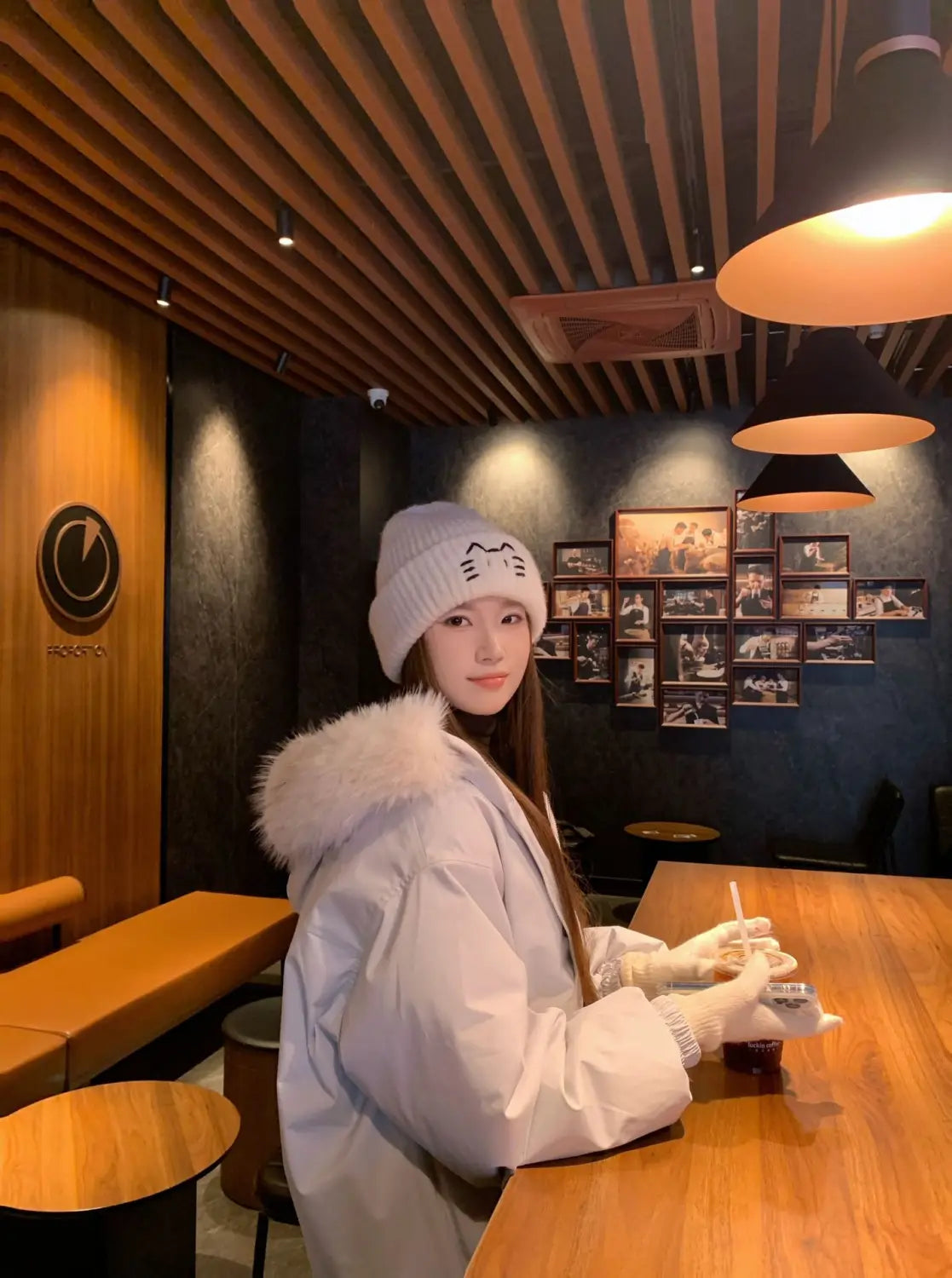 White knit beanie with cat face embroidery and fluffy white fur trim designed for warmth and style.