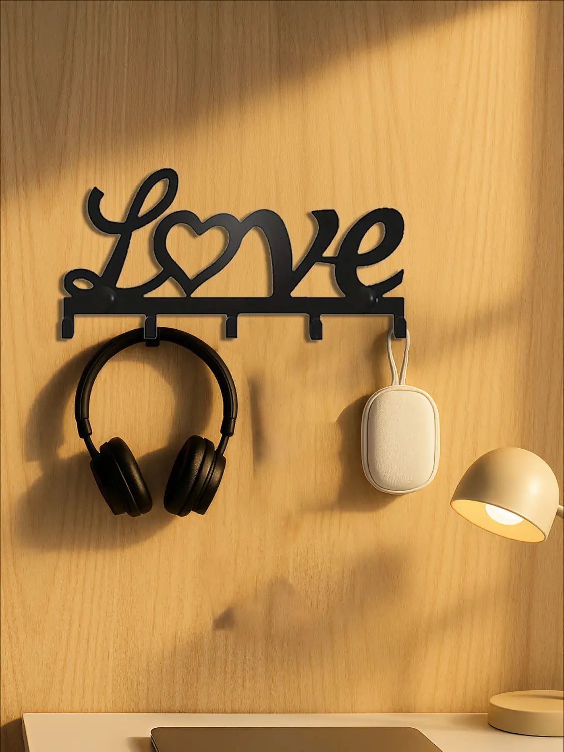 Black metal love wall hook rack with heart design featuring five pegs for hanging keys and accessories.