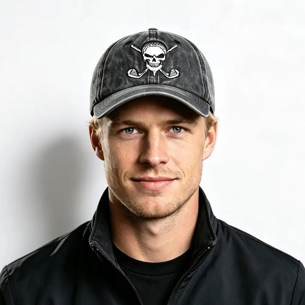 A dark gray distressed baseball cap made of vintage fabric featuring a white embroidered skull with crossed golf clubs behind it.