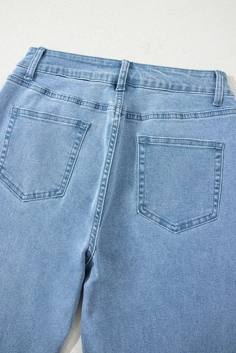 Jean à taille haute en denim rose effiloché à jambes larges, en denim délavé clair, avec un design de poche arrière classique et des surpiqûres visibles, présenté sur le côté arrière.