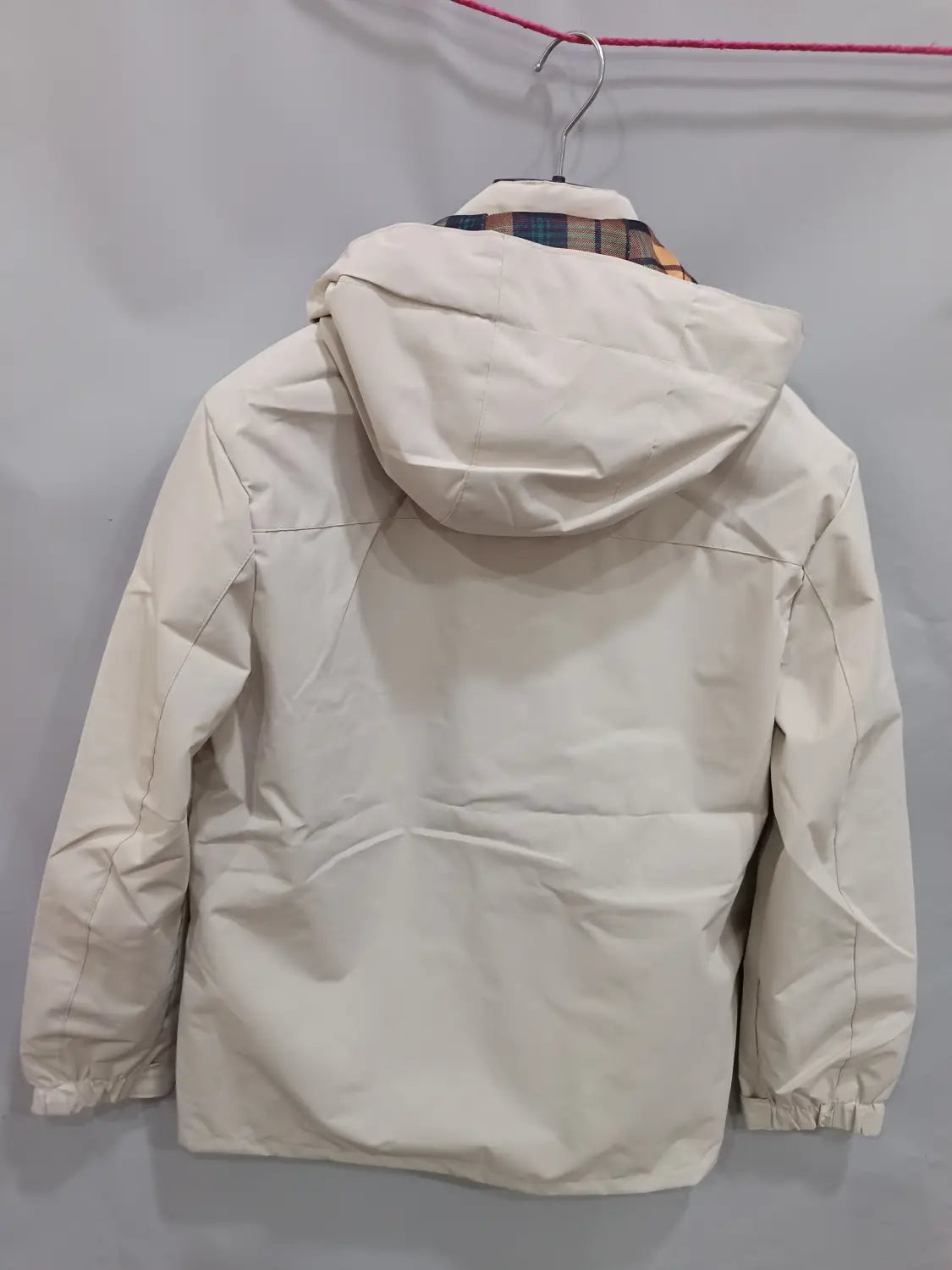 Men winter hooded parka coat in cream color with puffer material and plaid lining visible at the collar.