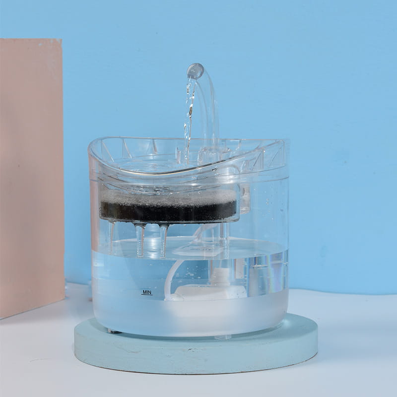 Fontaine à eau intelligente pour animal de compagnie en plastique transparent de 1,8 L, avec une couche de filtre noire et un bec courbé distribuant de l’eau.